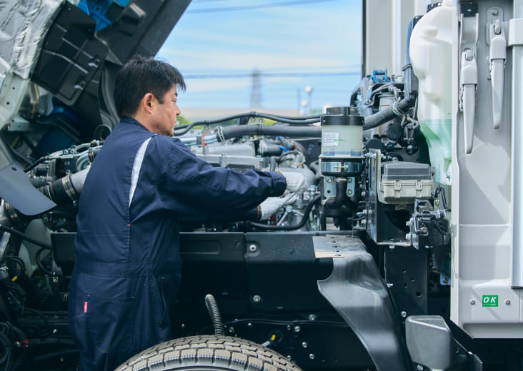 トラックを整備中のドライバー