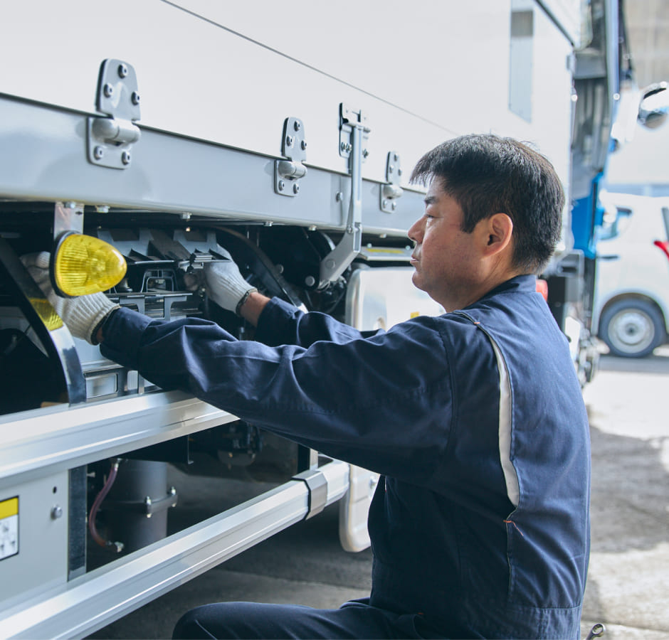 トラックを整備中のドライバー