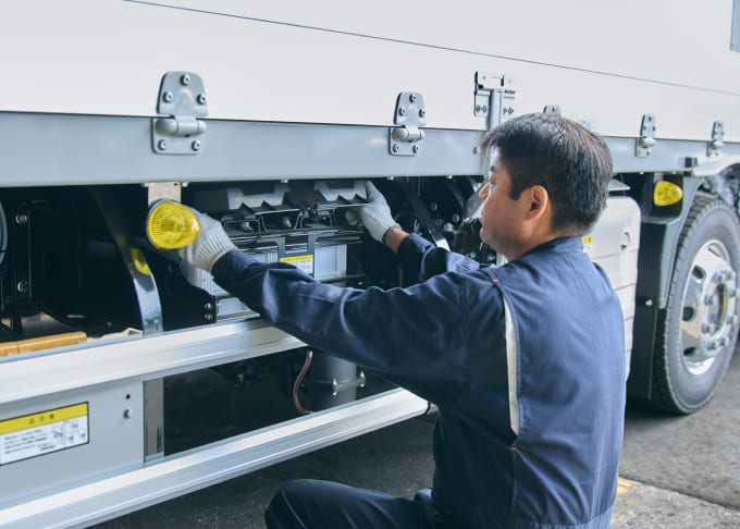 トラックを整備するドライバー